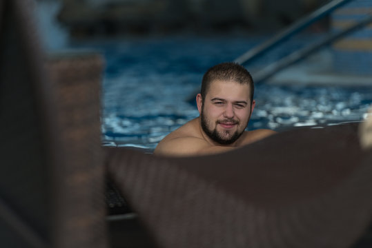 Overweight Man Resting Relaxed On Edge Of Pool