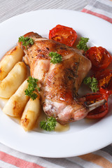 Rabbit leg roasted with apples on a plate closeup. vertical