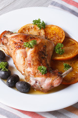 roasted rabbit leg with oranges and olives. vertical