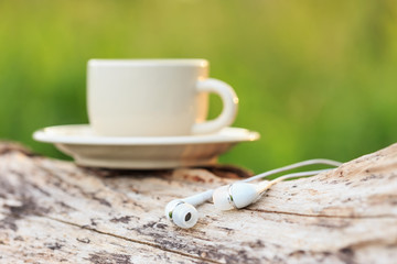 Close up Headphones and Coffee cup on the table in the morning