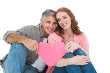 Casual couple holding pink heart