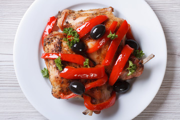 Rabbit leg meat fried with peppers and olives top view