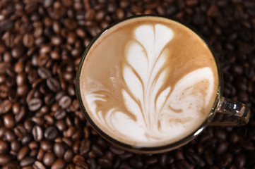 Latte art, coffee in coffee beans background.