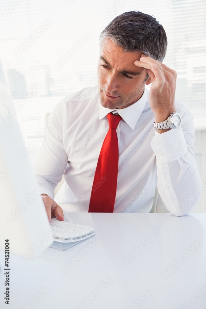 Poster concentrated businessman using computer and thinking
