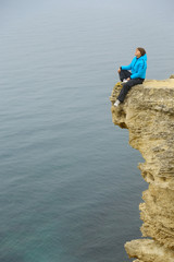 Fototapeta na wymiar beautiful woman on a cliff above the sea