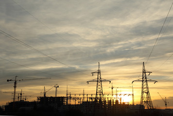 power lines going to the construction site at sunset