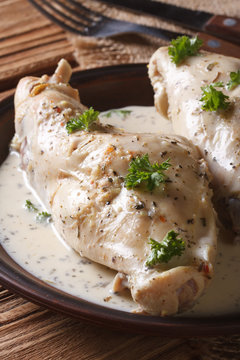 Rabbit meat stewed in sour cream close-up on a plate. vertical