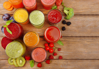 Glasses of tasty fresh juice, on wooden table.