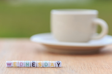 Wednesday written in letter beads and a coffee cup on table