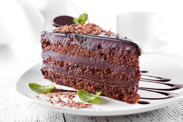 Delicious chocolate cake on plate on table on light background