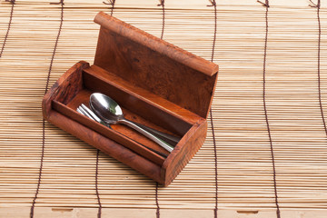 Wooden cutlery box on wood background.