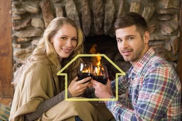 Romantic couple toasting wineglasses in front of lit fareplace