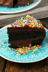Chocolate cake with colorful sweet powder on table close-up