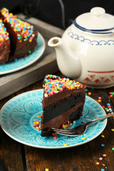 Chocolate cake with colorful sweet powder on table close-up