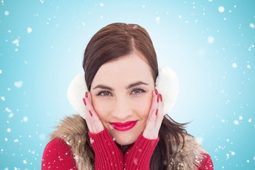 Composite image of brunette in winter clothes smiling at camera