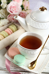 Composition with colorful macaroons, teapot and up of tea