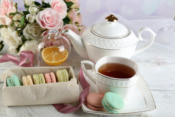 Colorful macaroons with cup of tea