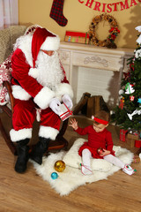 Santa Claus giving  present to  little cute girl near