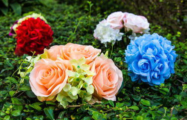 Round colorful bouquet of roses arranged above the grass leaf