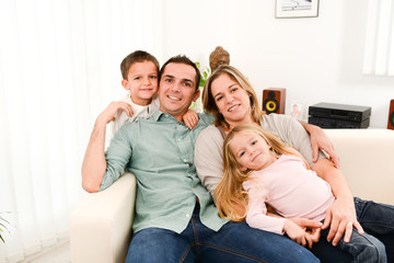 happy cheerful family playing together in the sofa at home