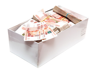 Пачки российских денег в коробке на белом фоне