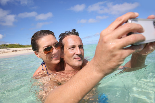 Couple in Caribbean sea taking picture of themselves