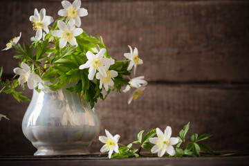 snowdrops in vase  on wooden background