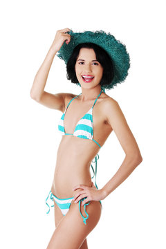 Young slim woman wearing swimwear and summer hat