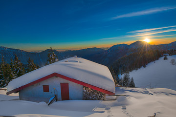 Alpin hut in the snow during sunset