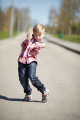 Fototapeta premium little boy grimacing on the street in april