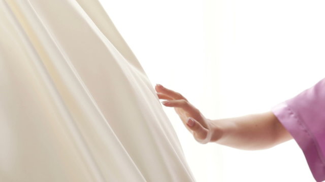 Bride touching wedding dress