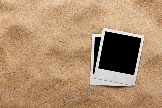Old style empty photo cards lying on a sea sand