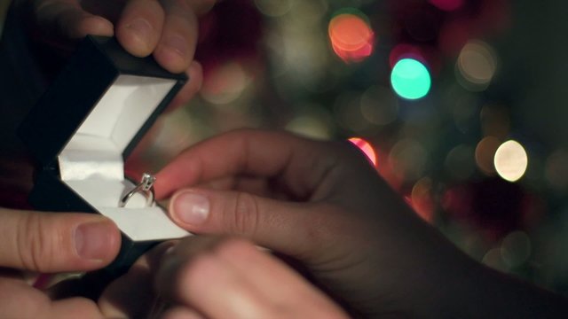 Engagement Ring Proposal Close Up. Christmas Tree Background 