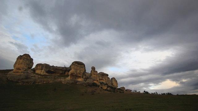 clouds running above stone rocks