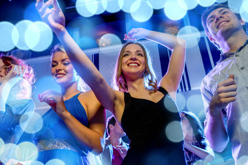 smiling friends dancing in club