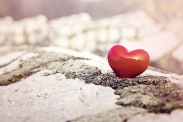 Fototapeta premium Single red heart on pebble stones, still life.