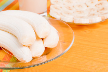 peeled banana on the table next to a yellow banana juice