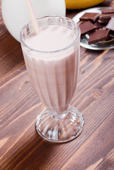 banana chocolate cocktail behind bananas and chocolate milk