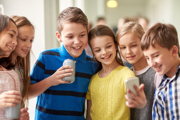 group of school kids with smartphone and soda cans