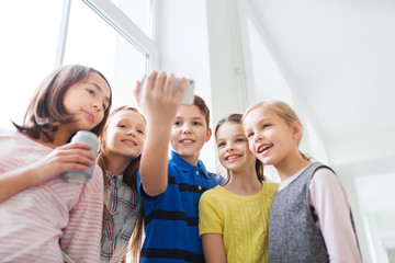 group of school kids with smartphone and soda cans