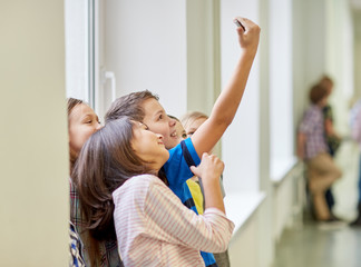 Fototapeta premium group of school kids taking selfie with smartphone