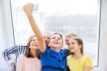 group of school kids taking selfie with smartphone