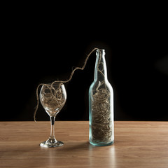 Wine bottle and glass filled with twine
