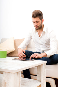 Junger Mann mit Tablet Pc auf dem Sofa