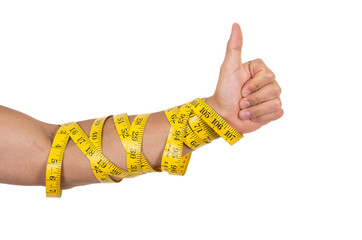 man's arm wrapped in measuring tape holding thumb up