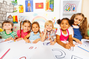 Group of kids, boys and girls in reading class