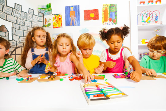 Large group of kids play with modeling clay