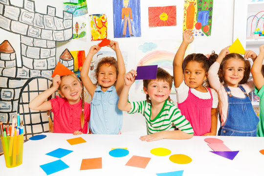 Happy little kids with color cardboard shapes