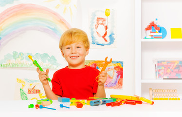 Cute preschool blond boy with toy work tools
