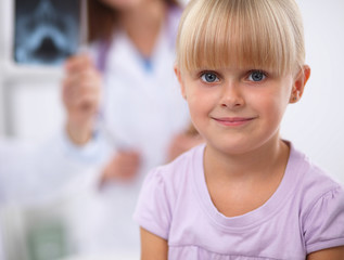 Female doctor examining child with stethoscope at surgery